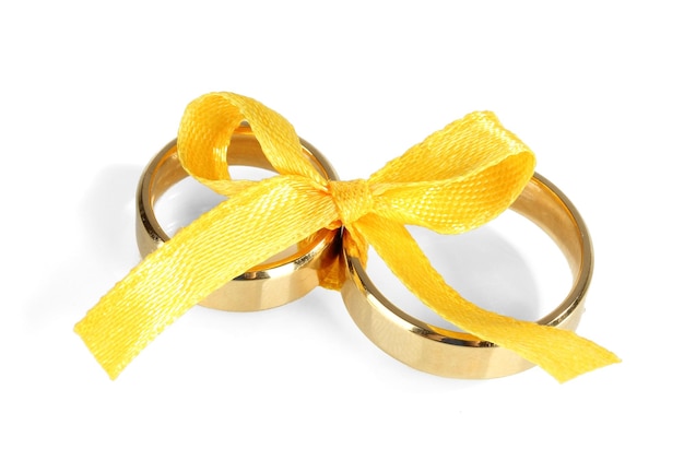 Фото Обручальные кольца, перевязанные лентой, изолированной на белом