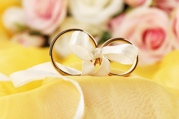 写真 明るい背景にリボンで縛られた結婚指輪