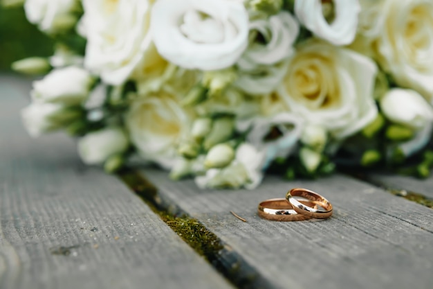 Wedding rings with bridal bouquet lying on the morning of the bride.