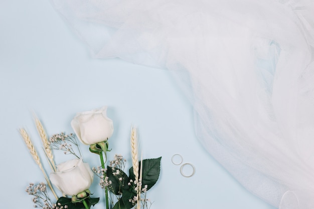 Wedding rings with flowers and bridal veil