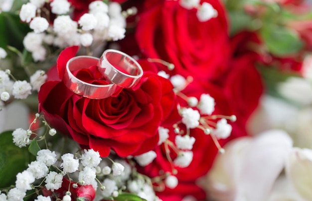 Wedding rings with flowers on red velvet background