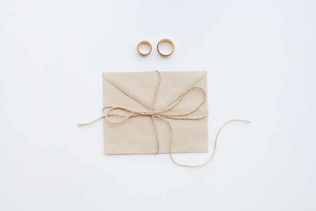 Wedding rings with invitation and brown thread