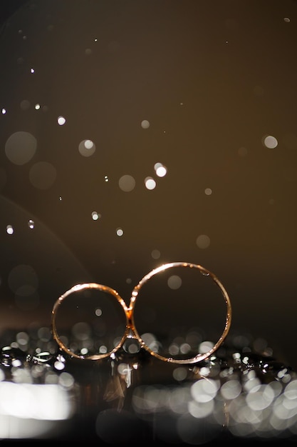 Wedding rings with water droplets,the engagement ring
set.,beautiful silver background with wedding rings and stars