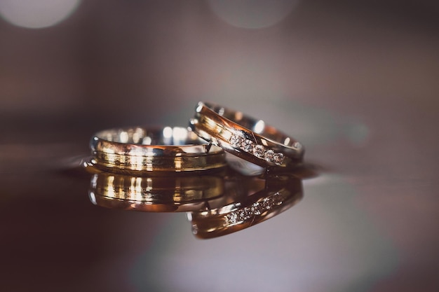 Обручальные кольца на деревянной коробке с тенями листьев