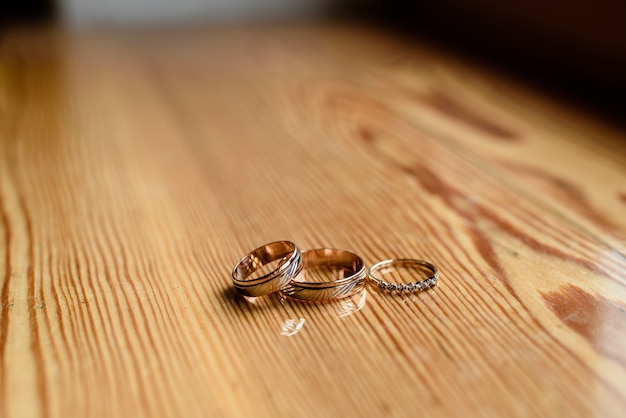 Wedding rings on a wooden surface.