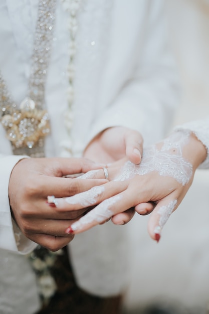 結婚式のロマンチックなカップルは結婚指輪を着用します