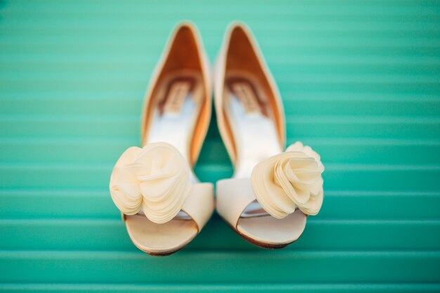 Scarpe da sposa della sposa su uno sfondo di legno blu