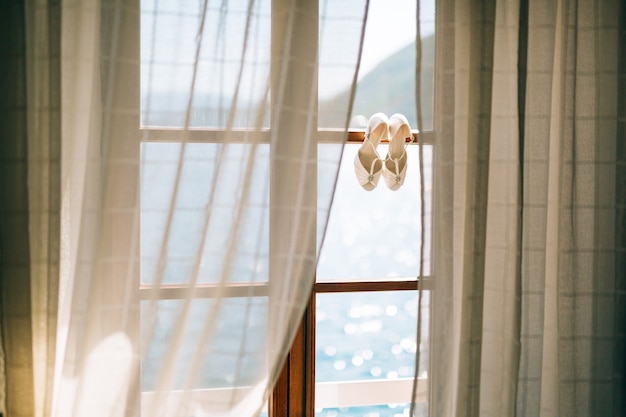 Wedding shoes of the bride at a window