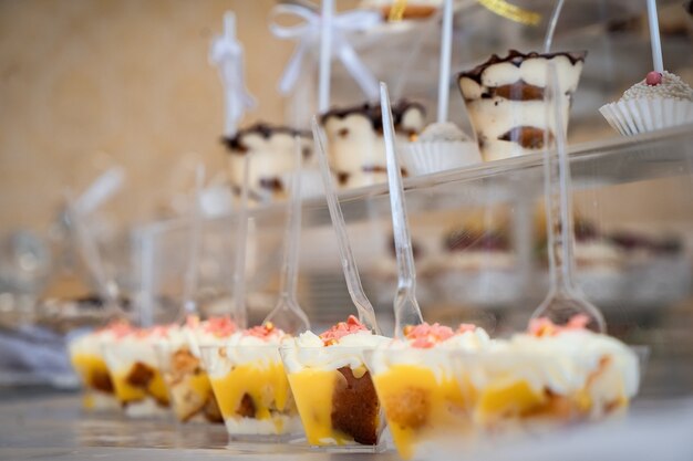 Свадебные сладости, украшенные столы, украшения и кексы, вкусные торты и деликатесы.