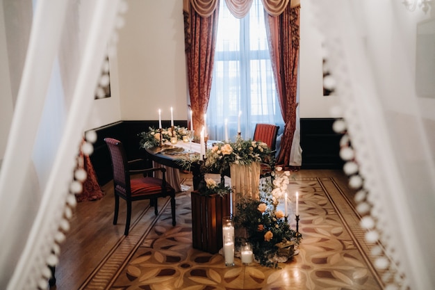 Wedding table decoration with flowers on the table in the castle, table decor for dinner by candlelight.Dinner with candles.