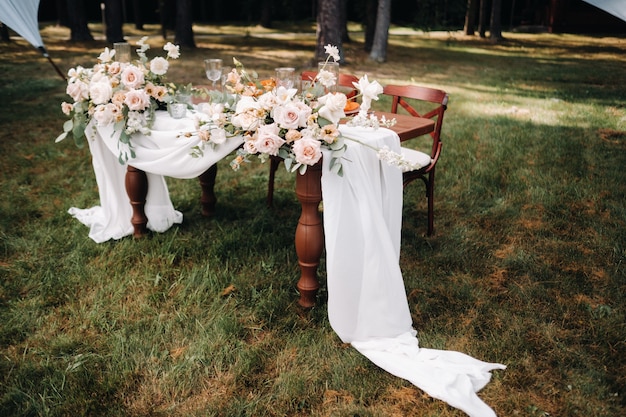 テーブルの上に花が付いている結婚式のテーブルの装飾、夕食のテーブルの装飾。