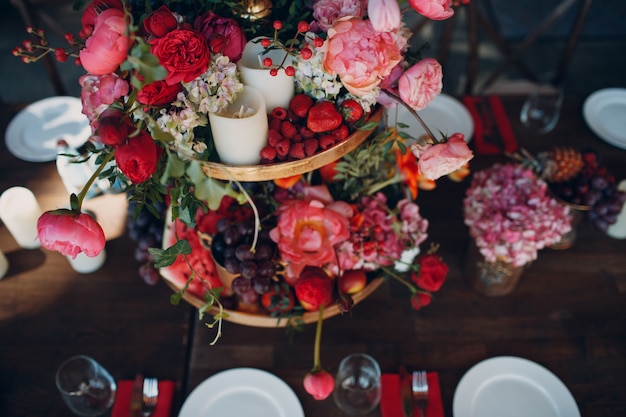 Wedding table flowers with fruits and berries decor in red white pink green colors