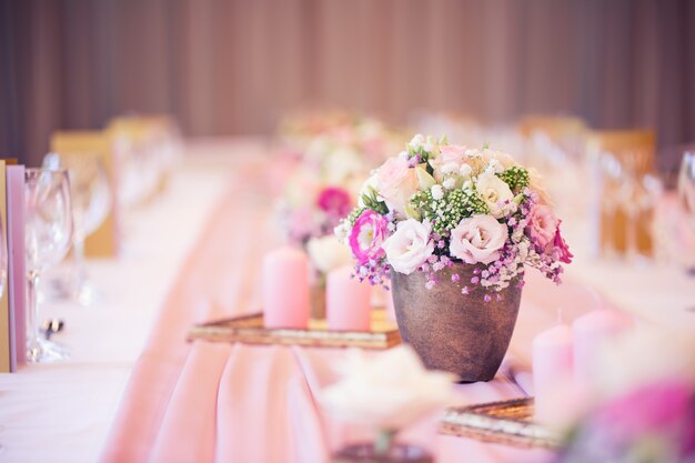 Photo wedding table setting. beautiful table set with flowers and glass cups  for some festive event, party or wedding reception.