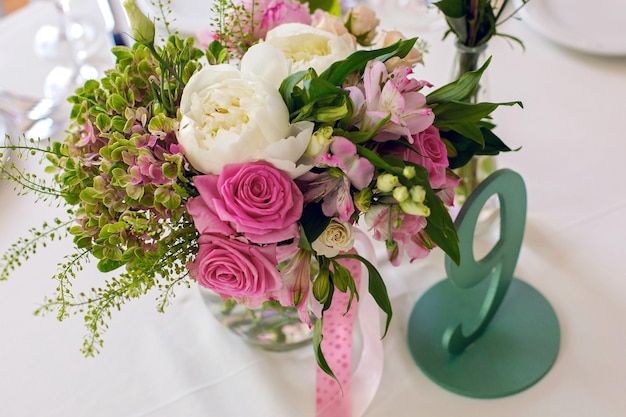 写真 緑色のろうそくと花を飾った結婚式のテーブルセット