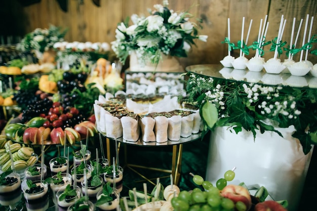 Wedding table with appetizers and fruits and desserts at the ceremony catering