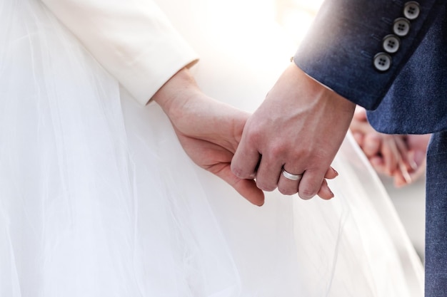 お祝いの結婚の日に夕日の背景の恋人の結婚式の画像に手をつないで結婚式のテーマのカップル