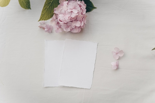 Foglio bianco mockup tropicale per matrimoni su sfondo tessile invito a nozze con vista dall'alto flatlay