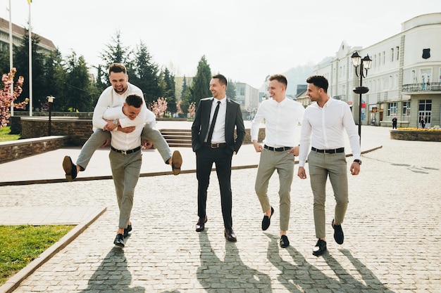 Wedding. Wedding day. Groom with groomsmen walking after wedding ceremony.