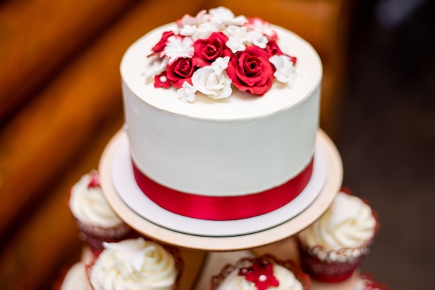 Torta nuziale bianca con un nastro rosso decorativo
