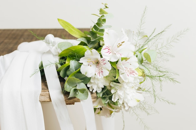 Свадебное белое платье и жасмин аурикулатум букет на деревянной доске