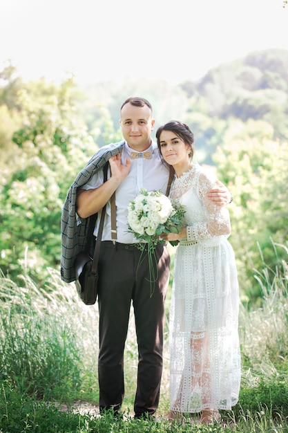 ヴィンテージスタイルの若い美しいカップルの結婚式。公園を散歩する新婚夫婦