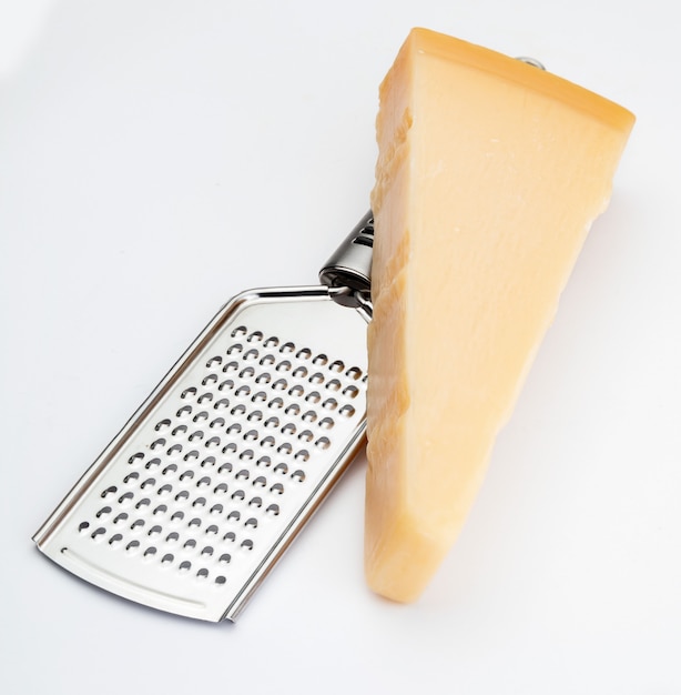 Wedge of Parmesan cheese or grana with grater. Isolated