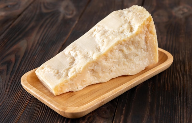 Wedge of parmesan cheese on wooden background