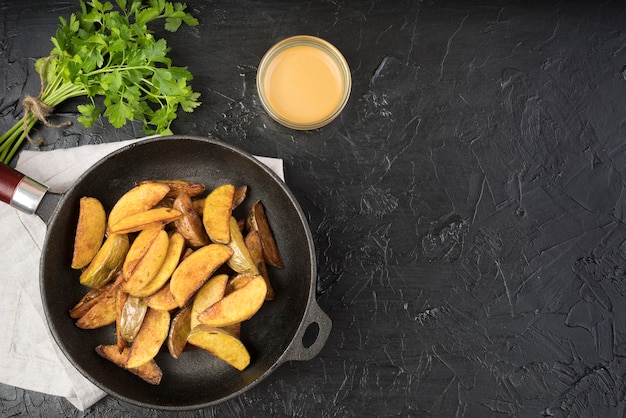 Photo wedges potatoes in pan with copy space