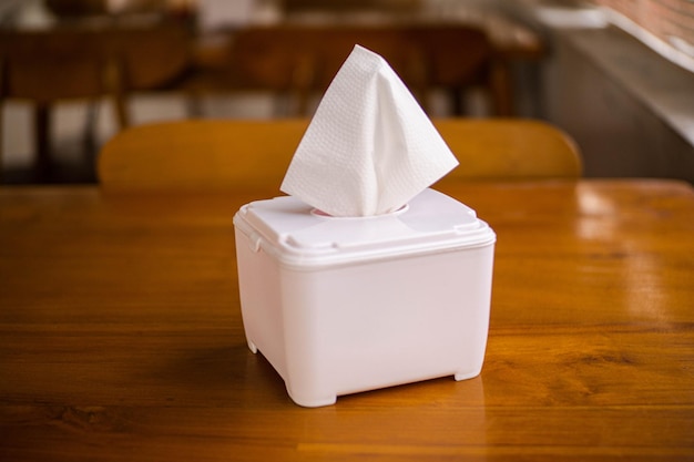Weefsels in een witte doos op een massieve houten tafel