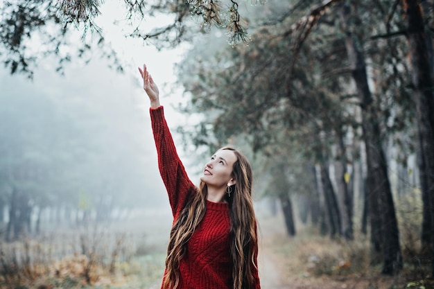 Выходные и отдых в лесу остаются ближе к природе молодая женщина в красной шляпе и свитере