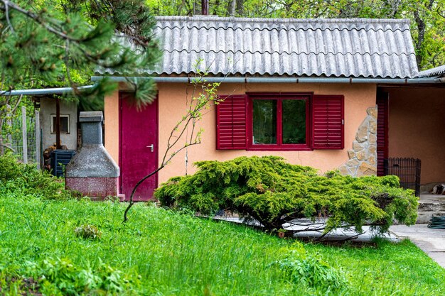 Дом выходного дня с красным окном в саду весной