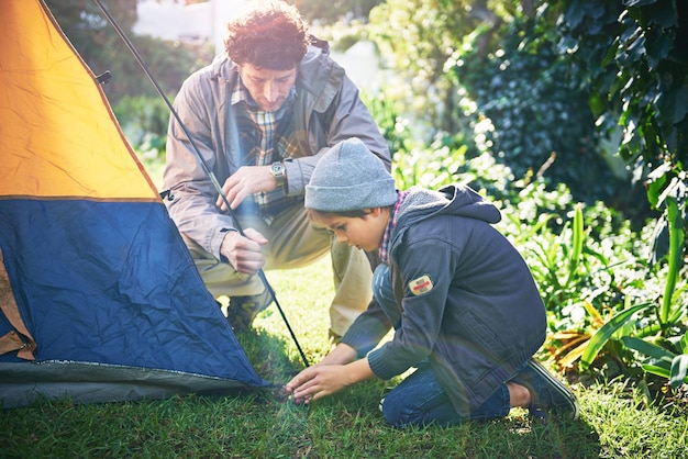 Weekend in de vrije natuur met papa Shot van een vader en zijn zoontje die hun tent opzetten