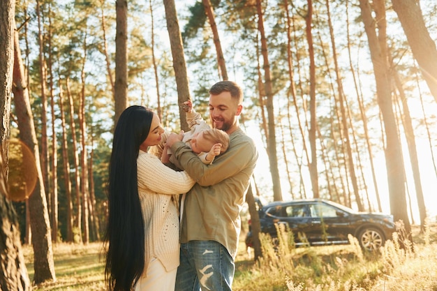 Weekend rest Happy family of father mother and little daughter is in the forest