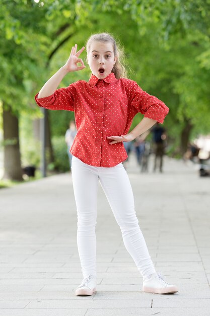 Weekend walk. Girl carefree child. Kid walking sunny day. Summer holidays. Emotional kid in park nature background. Charming stylish fashionable girl in park. Little child enjoy walk in park.