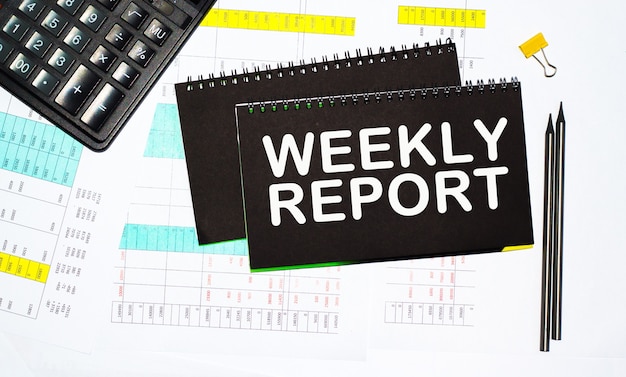 Weekly report text, calculator and pen are on the desktop. calculator and pen. Business concept.