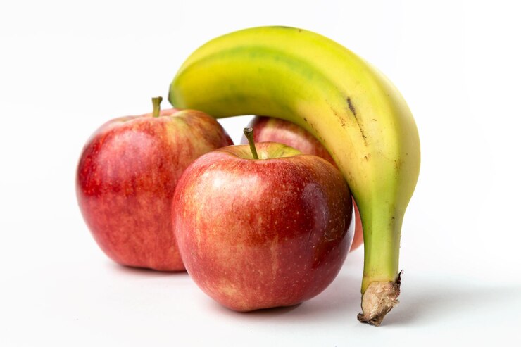 Weergave van drie appels en een kanarie banaan op witte achtergrond