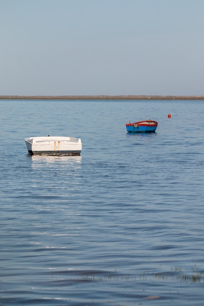 Weergave van twee eenzame vissersboten op de Algarve.