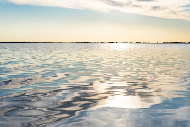 Foto weerspiegelde zonnestralen op zeewater. schittering op het water in de vorm van sterren. natuurlijke abstracte zeewater achtergrond.