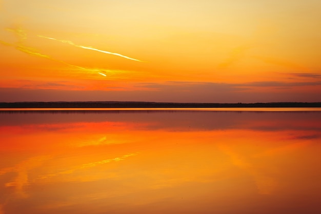 Weerspiegeling van een prachtige gouden zonsondergang over het water