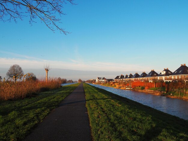 Weg door gebouwen tegen een heldere blauwe lucht