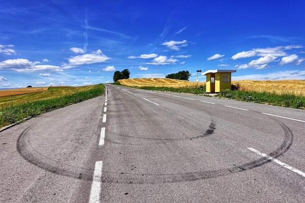 Weg door landschap tegen blauwe lucht