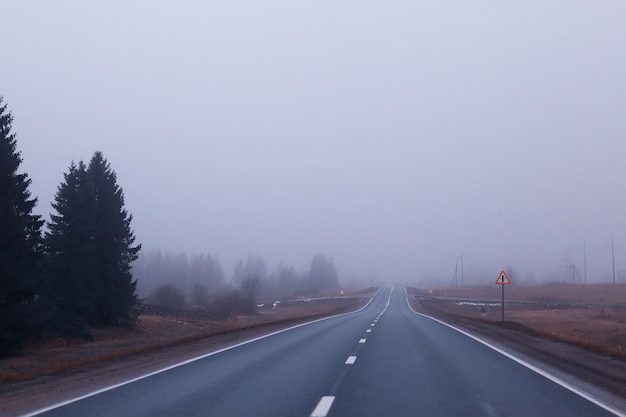 Weg in mistconcept, mist in oktober halloween-landschap, snelweg