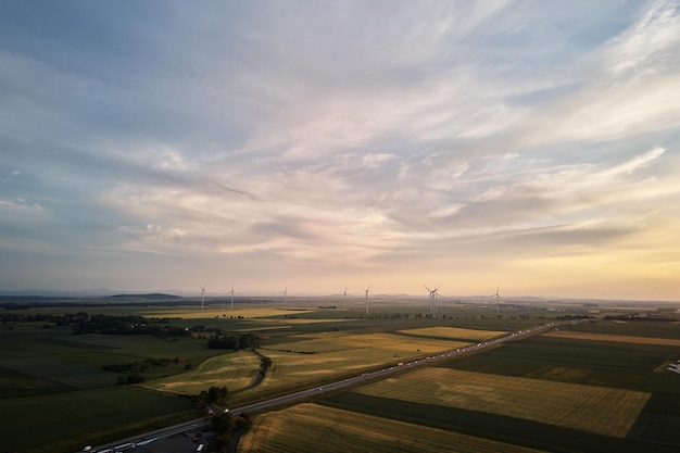 Weg met autoverkeer en windmolenturbines bij zonsondergang