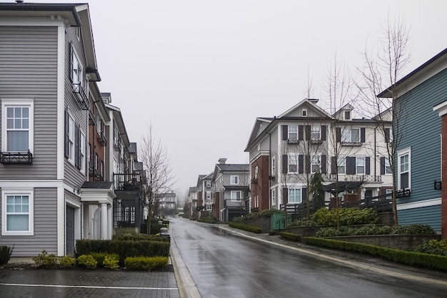 Weg met nieuwe residentiële herenhuizen op bewolkte regenachtige dag