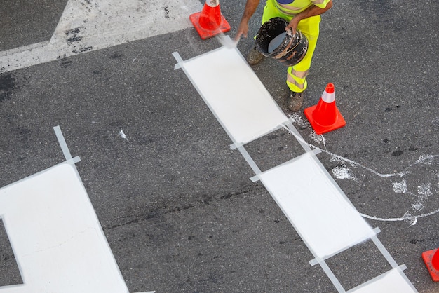 Wegenschilder werknemer bezig met zebrapad van een stadsstraat