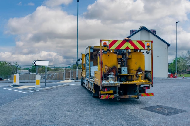 Wegenwerkers die hotmelt-verkeersbestendige verf aanbrengen voor witgele en rode wegmarkeringslijnen