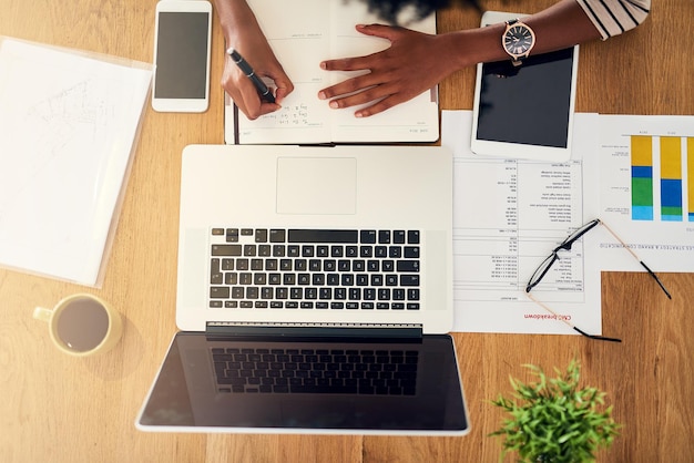 Wegwerken Hoge hoekopname van een onherkenbare vrouw die thuis op haar laptop werkt