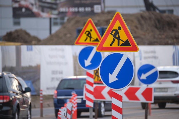 Wegwerkzaamheden die verkeersborden waarschuwen voor bouwwerkzaamheden op straat in de stad en langzaam rijdende auto's