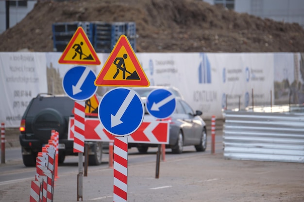 Wegwerkzaamheden die verkeersborden waarschuwen voor bouwwerkzaamheden op straat in de stad en langzaam rijdende auto's