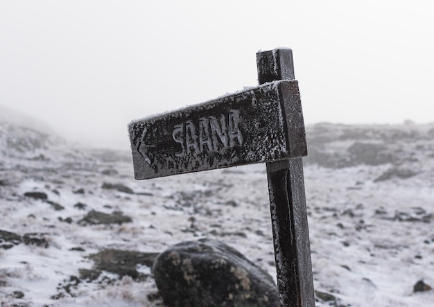 Wegwijzer in de sneeuw op een mistige herfstdag bergsauna in Finland
